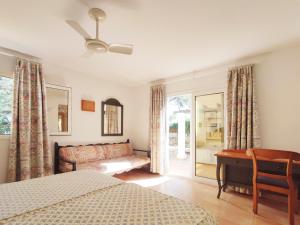 um quarto com uma cama, um sofá e uma mesa em Casa Rainer em Es Figueral Beach