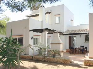 uma casa branca com uma área de jantar em frente em Casa Rainer em Es Figueral Beach