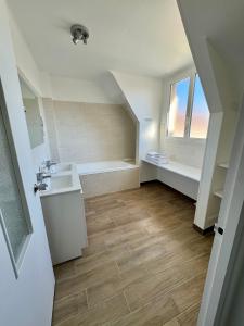 uma casa de banho com um lavatório e uma banheira em Le Clos Normand em Saint-Aubin-sur-Mer