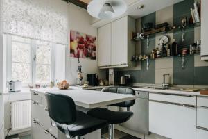 cocina con armarios blancos, mesa y sillas en Privat-Gästezimmer LA-Villa-Feeling, en Landshut