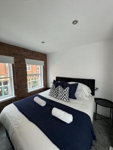 a bedroom with a large bed with blue and white pillows at Central Hull Apartments in Hull