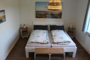 - une chambre avec un lit et un lustre dans l'établissement Huus ButterbeidieFische Wohnung 8, à Wyk auf Föhr