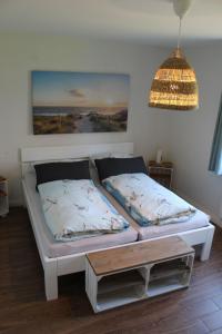 - une chambre avec 2 lits et une table dans l'établissement Huus ButterbeidieFische Wohnung 8, à Wyk auf Föhr