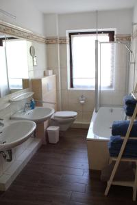 La salle de bains est pourvue de 2 lavabos, d'une baignoire et de toilettes. dans l'établissement Huus ButterbeidieFische Wohnung 8, à Wyk auf Föhr