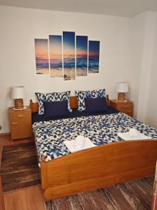 a bedroom with a bed with three paintings on the wall at Apartman Vera in Crikvenica