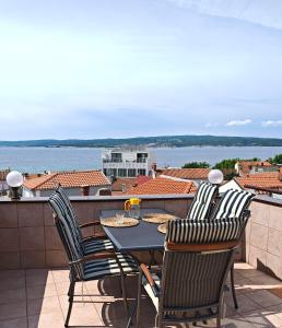 a table and chairs on a balcony with a view of the water at Apartman Vera in Crikvenica
