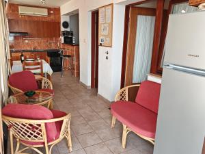 a room with chairs and a table and a refrigerator at Apartman Vera in Crikvenica