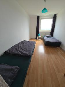 1 Schlafzimmer mit 2 Betten und Holzboden in der Unterkunft Ferienwohnung Buffon in Wertheim