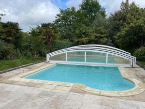 una piscina con copertura sopra di Maison verdoyante avec piscine, 5 min du Mans - FR-1-410-443 a La Chapelle-Saint-Aubin