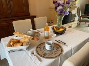 un tavolo con un piatto di pane e un vaso di fiori di Maison verdoyante avec piscine, 5 min du Mans - FR-1-410-443 a La Chapelle-Saint-Aubin