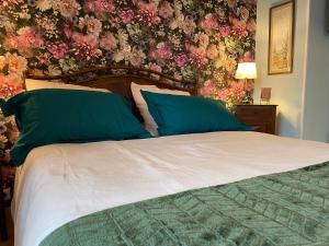 una camera da letto con un letto grande con carta da parati floreale di Maison verdoyante avec piscine, 5 min du Mans - FR-1-410-443 a La Chapelle-Saint-Aubin