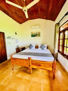 a bedroom with a bed with a wooden ceiling at Lake View Cottage in Tissamaharama