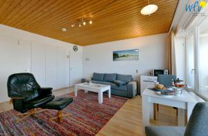 a living room with a couch and a chair at Haus Poseidon Ferienwohnung Nordseeblick in Wangerooge