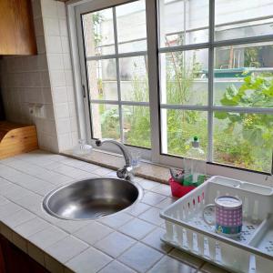 eine Küchentheke mit Spüle und Fenster in der Unterkunft CRALS - Casa da Guilheta in Esposende