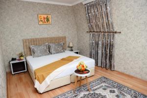 Un dormitorio con una cama y una mesa con un bol de fruta. en Nemi Hotel Baku en Bakú