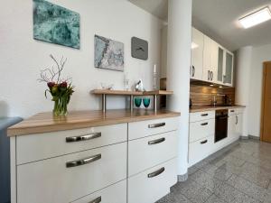 uma cozinha com armários brancos e um balcão em Seesicht em Überlingen