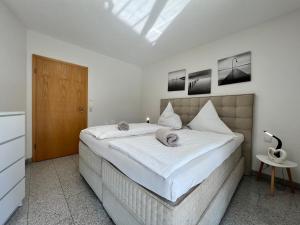 um quarto com uma cama grande e lençóis brancos em Seesicht em Überlingen