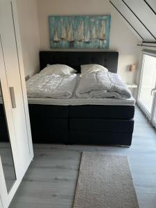 a bed with white sheets and pillows in a bedroom at Hafen im Blick in Kappeln