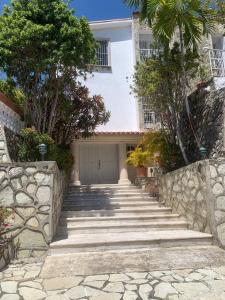 uma casa branca com escadas que levam a uma garagem em Rincon Andaluz em Santo Domingo