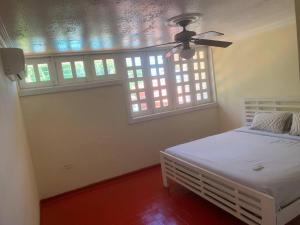 um quarto com uma cama e uma ventoinha de tecto em Rincon Andaluz em Santo Domingo