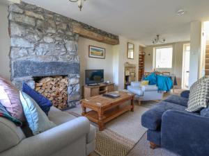 a living room with couches and a stone fireplace at Glasfryn in Dolgellau