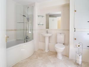 a white bathroom with a toilet and a sink at Glasfryn in Dolgellau +17 photos