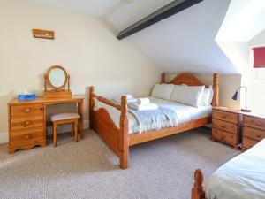 a bedroom with a bed and a desk and a mirror at Glasfryn in Dolgellau