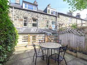 a patio with a table and chairs in front of a building at Glasfryn in Dolgellau