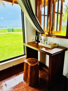a table in a room with a large window at Lake View Cottage in Tissamaharama