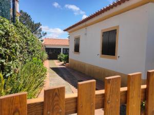 una valla de madera frente a una casa en A place in the sun, en Longueira