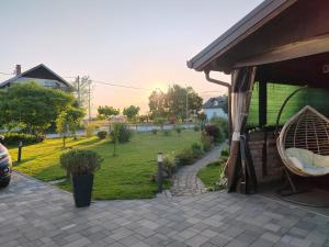 a patio with a chair and a grass yard at Apartmani Vinea Zara in Brčevec