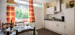 a kitchen with a dining table and a window at Ferienhaus an der Baeke B in Bad Zwischenahn