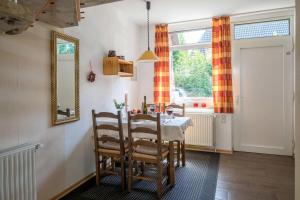ein Esszimmer mit einem Tisch, Stühlen und einem Spiegel in der Unterkunft Ferienhaus an der Baeke B in Bad Zwischenahn