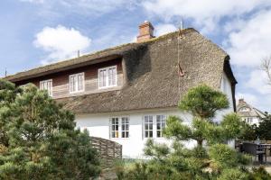 a large white house with a thatched roof at Victoria in Keitum