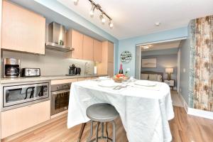 多倫多的住宿－300 Front Suites，厨房配有一张桌子,上面有白色的桌布