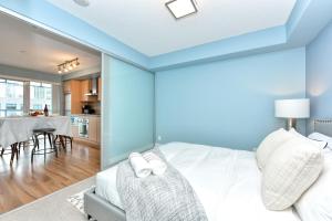 多倫多的住宿－300 Front Suites，一间带白色床的卧室和一间用餐室