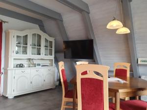 ein Esszimmer mit einem Tisch und einem TV in der Unterkunft Nurdachhaus EIN HAUS AM DEICH in Butjadingen