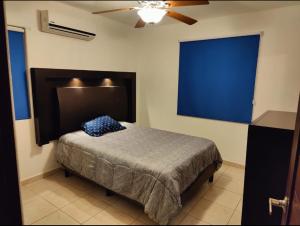 a bedroom with a bed with a blue headboard at Departamento Brisas del Mar Nuevo Altata in Altata