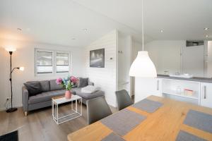 a living room and kitchen with a table and a couch at Ostseecamp Chalet Haffkrug No 55 in Scharbeutz
