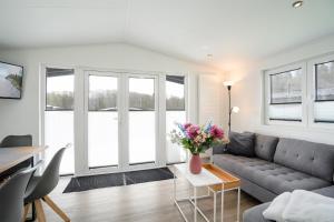 a living room with a couch and a table with flowers at Ostseecamp Chalet Haffkrug No 55 in Scharbeutz