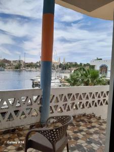 een patio met een stoel en uitzicht op het water bij NiLe ViEW RANA NUbian Guest HOUES in Aswan