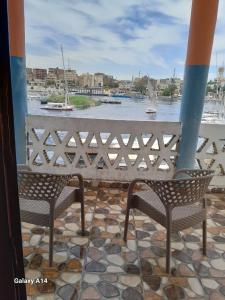 balcone con 2 sedie e vista sul fiume di NiLe ViEW RANA NUbian Guest HOUES a Aswan