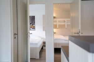 a bedroom with a bed and a bunk room at Ostseecamp Chalet Haffkrug No 59 in Scharbeutz