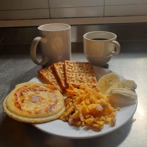 a plate of breakfast food with eggs toast and bread at Hotel Plaza Real in Santa Rosa de Cabal