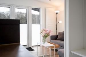 a living room with a vase of flowers on a table at Ostseecamp Chalet Haffkrug No 59 in Scharbeutz