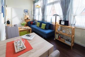 a living room with a blue couch and a table at Strandkorb in der Villa Medici in Norderney