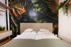 a bedroom with a bed with a tropical wallpaper at Picnic Lux 2plus2 Centrum in Kőszeg