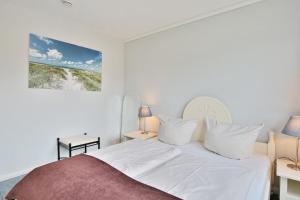 - une chambre avec un lit blanc et des oreillers blancs dans l'établissement Seesternresidenz Appartement 21, à Scharbeutz