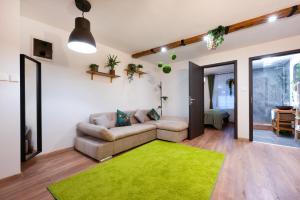 a living room with a couch and a green rug at Picnic Lux 2plus2 Centrum in Kőszeg