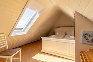 um quarto com uma cama num sótão com uma janela em Wandalennest em Greetsiel